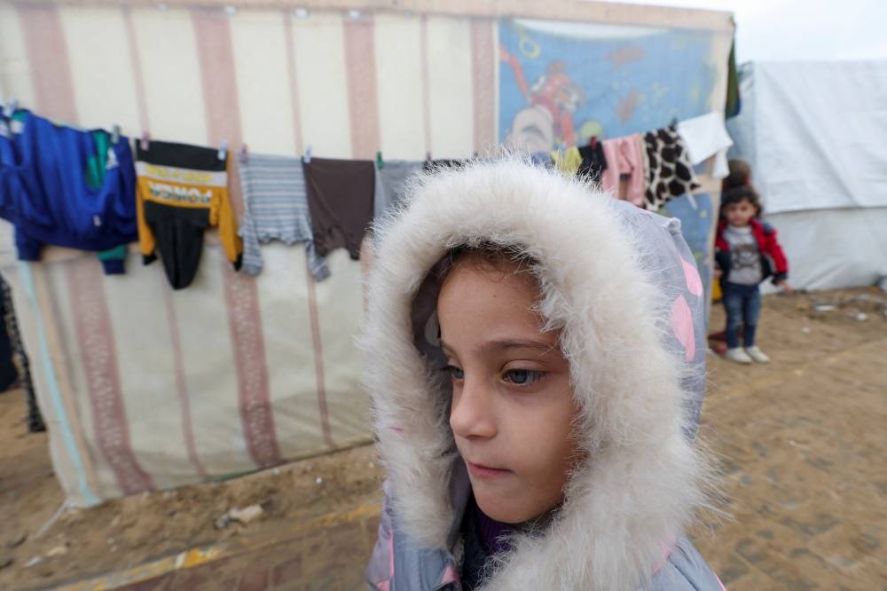 A child looks on as displaced Palestinians, who fled their houses due to Israeli strikes, shelter in a tent camp, in Rafah in the southern Gaza Strip, on Monday. REUTERS