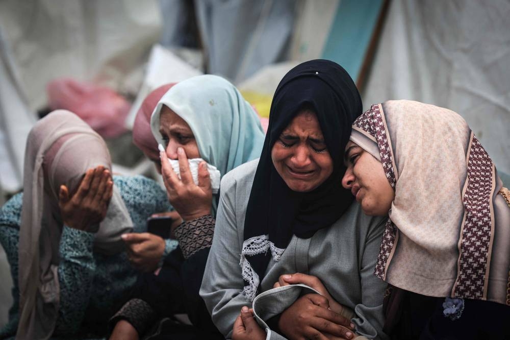 Palestinians mourn their relatives, killed in an overnight Israeli strike on the Al-Maghazi refugee camp, during a mass funeral at the Al-Aqsa hospital in Deir Al-Balah, in the southern Gaza Strip, on Monday. AFP