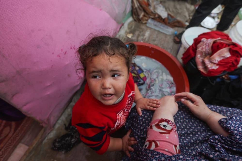 A child reacts, as displaced Palestinians, who fled their houses due to Israeli strikes, shelter in a tent camp, in Rafah in the southern Gaza Strip, on Monday. REUTERS