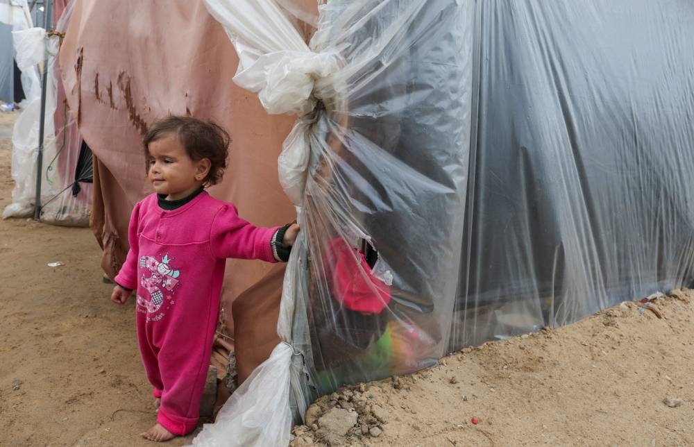 A child looks on as displaced Palestinians, who fled their houses due to Israeli strikes, shelter in a tent camp, in Rafah in the southern Gaza Strip, on Monday. REUTERS
