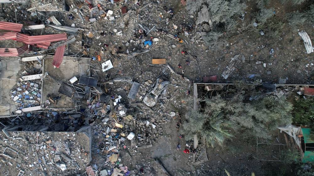 Palestinians gather at the site of Israeli strikes on houses, at the Maghazi camp in the central Gaza Strip, on Monday. REUTERS