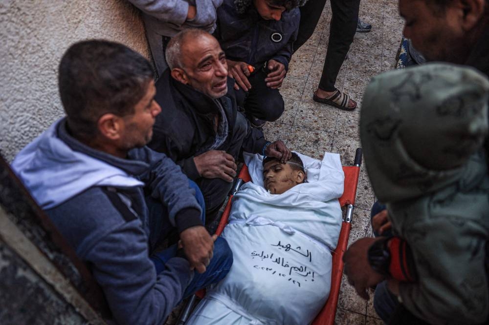 Relatives mourn by the body of Palestinian Ibrahim Abu Libda, killed during Israeli strikes in Rafah in the southern Gaza Strip, on Tuesday. AFP