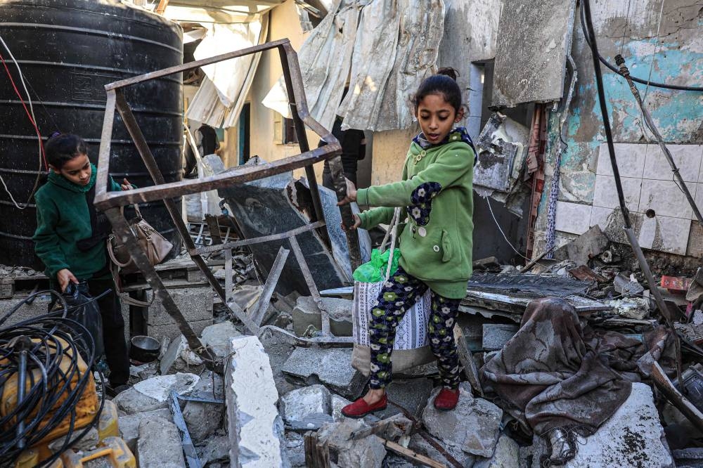 Palestinian girls search the rubble of a building following Israeli bombardment in Rafah in the southern Gaza Strip, on Tuesday. AFP