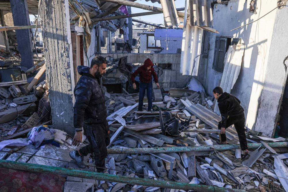 Palestinians search the rubble of a building following Israeli bombardment in Rafah in the southern Gaza Strip, on Tuesday. AFP