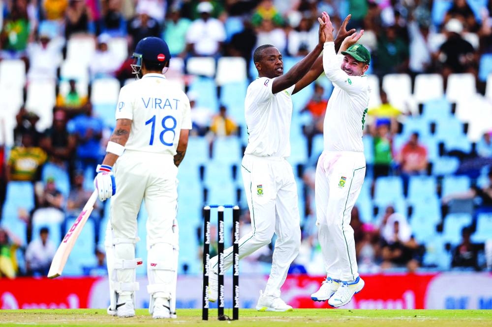 South Africa’s Kagiso Rabada (centre) celebrates with South Africa’s Dean Elgar (right) after the dismissal of India’s Virat Kohli during the first day of the first Test at SuperSport Park in Centurion on Tuesday. (AFP)