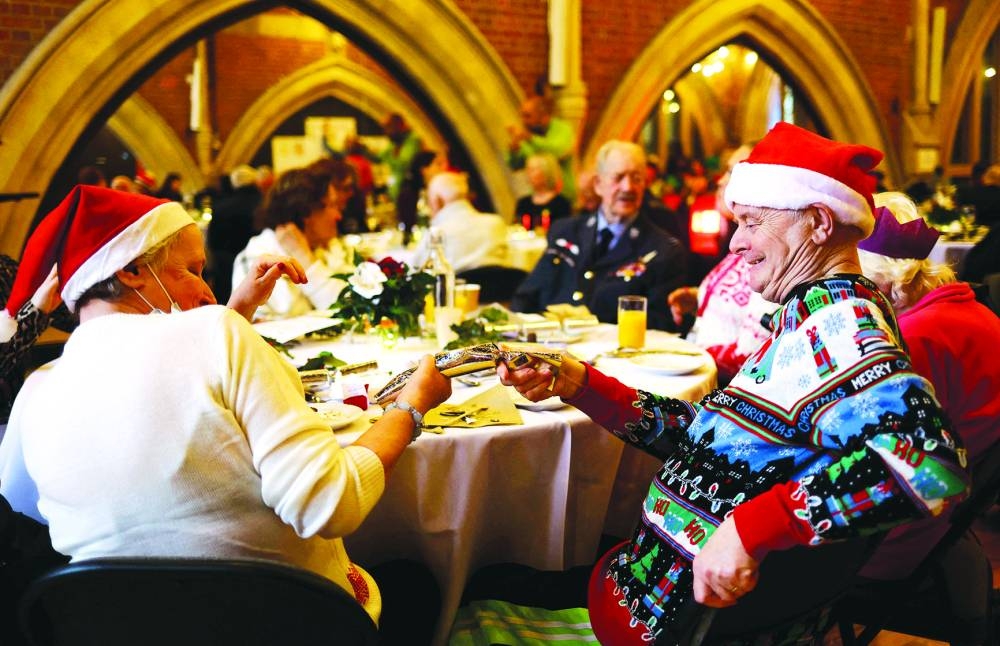 
Guests pull a cracker during lunch at Jacksons Lane Arts Centre, which has been catering for isolated older and disabled community members on Christmas Day since 1975, feeding around 100 people at the centre and delivering over 200 Christmas meals throughout the area, in north London. 