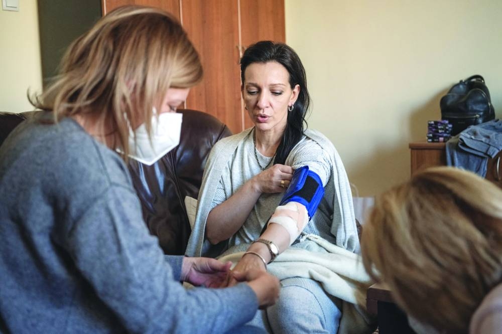 Marinika Tepic has her blood pressure checked at the state election commission headquarters where she is on a hunger strike in Belgrade on Tuesday. (Reuters) Page 10