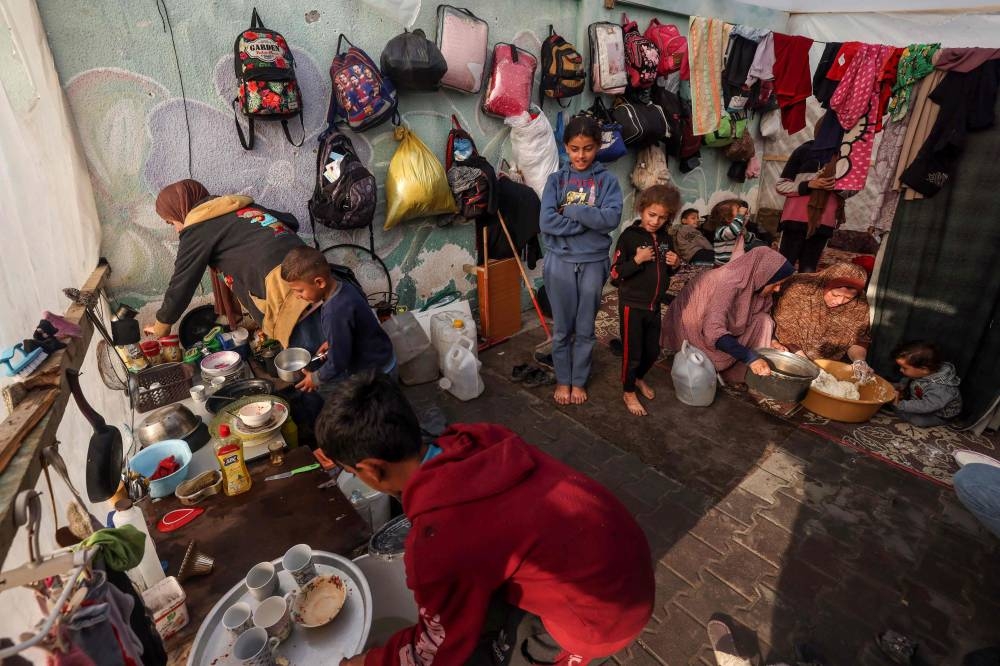 Displaced Palestinians go on with their lives inside a tent in Rafah in the southern Gaza Strip, on Wednesday. AFP