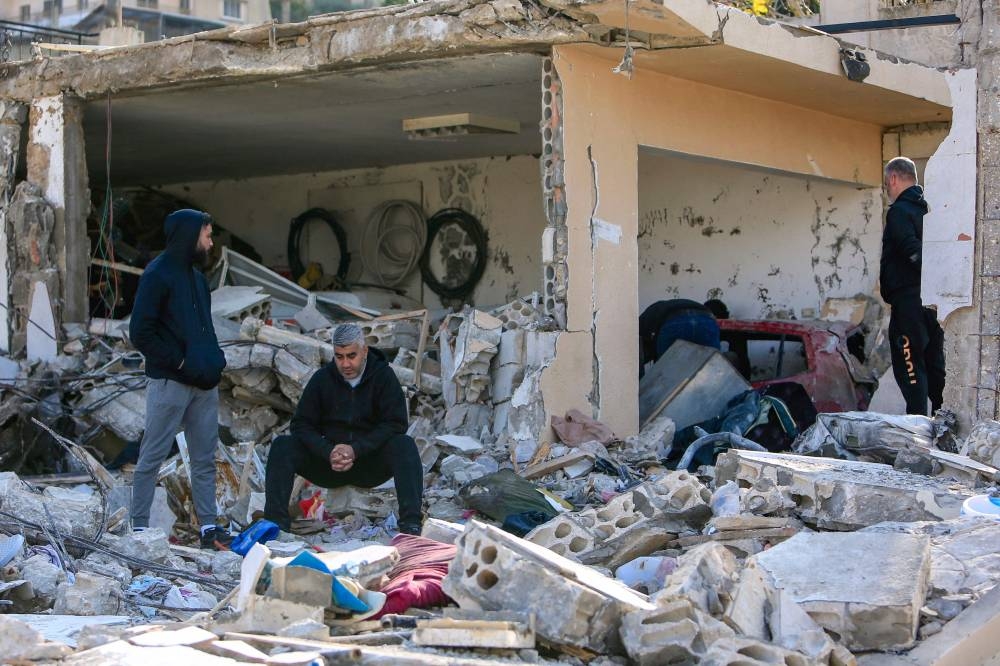 Men check the rubble of a building in Bint Jbeil in southern Lebanon near the border with Israel, following Israeli bombardment the previous night, on Wednesday. AFP