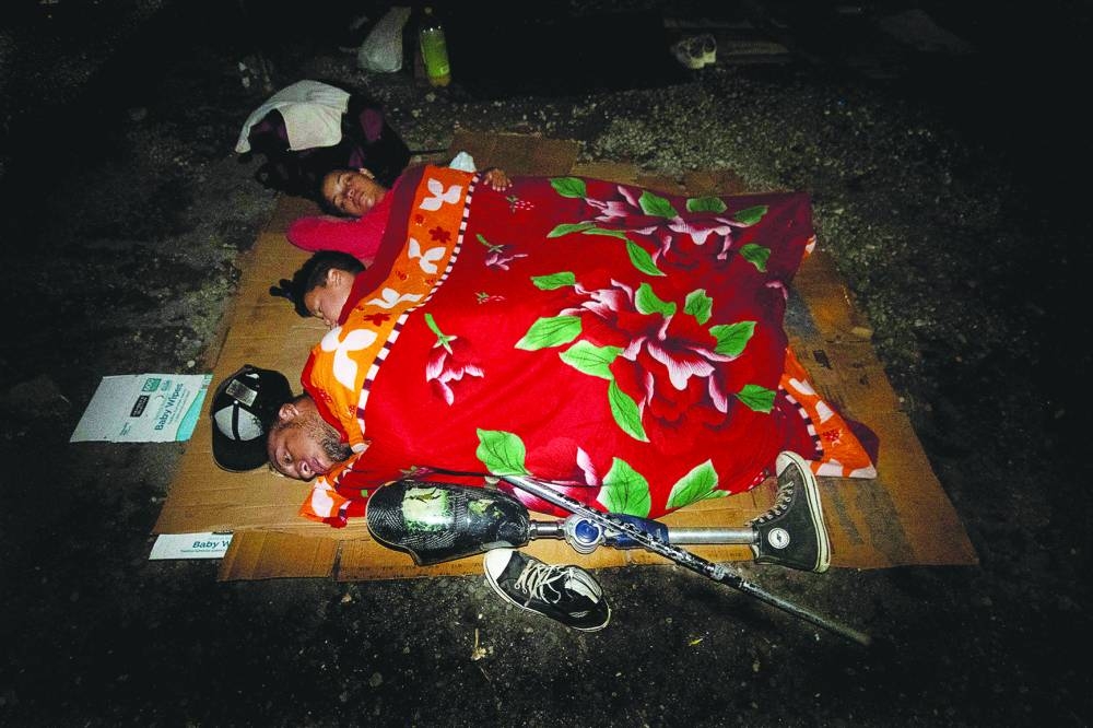 
Maldonado, (front) son Samuel Maldonado (centre) and wife Andrea Loreto (back) sleep at the Paso Canoas shelter in Puntarenas, Costa Rica. (AFP) 
