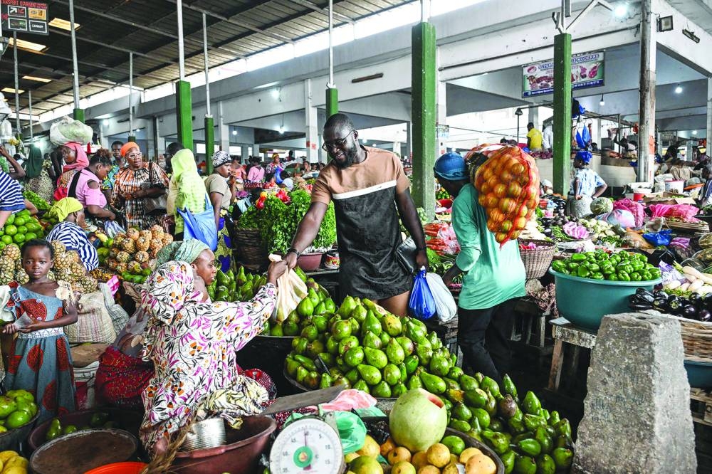 
Ivorian chef Charlie Koffi (centre) buys ingredients for the preparation of a gouagouassou sauce, at the Adjame market in Abidjan. 