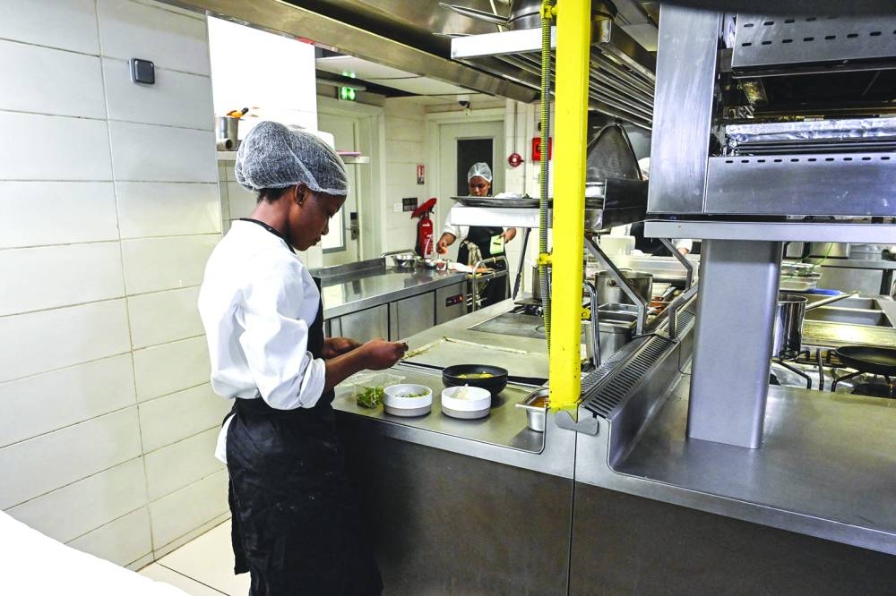 Chef Hermence Kadio prepares puffed cassava chips, grilled okra placali at the Maison Palmier restaurant in Abidjan.