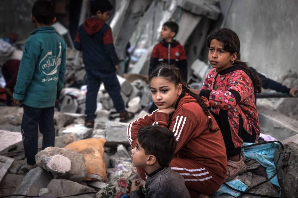 Children sit amid the rubble of destroyed buildings following Israeli bombardment in Rafah on the southern Gaza Strip, on Friday. AFP