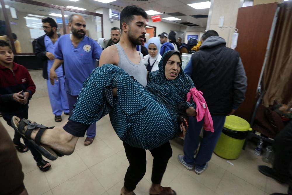 A woman injured in an Israeli bombardment is rushed to the emergency ward of the al-Aqsa hospital in Deir al-Balah in the central Gaza Strip on Saturday. AFP