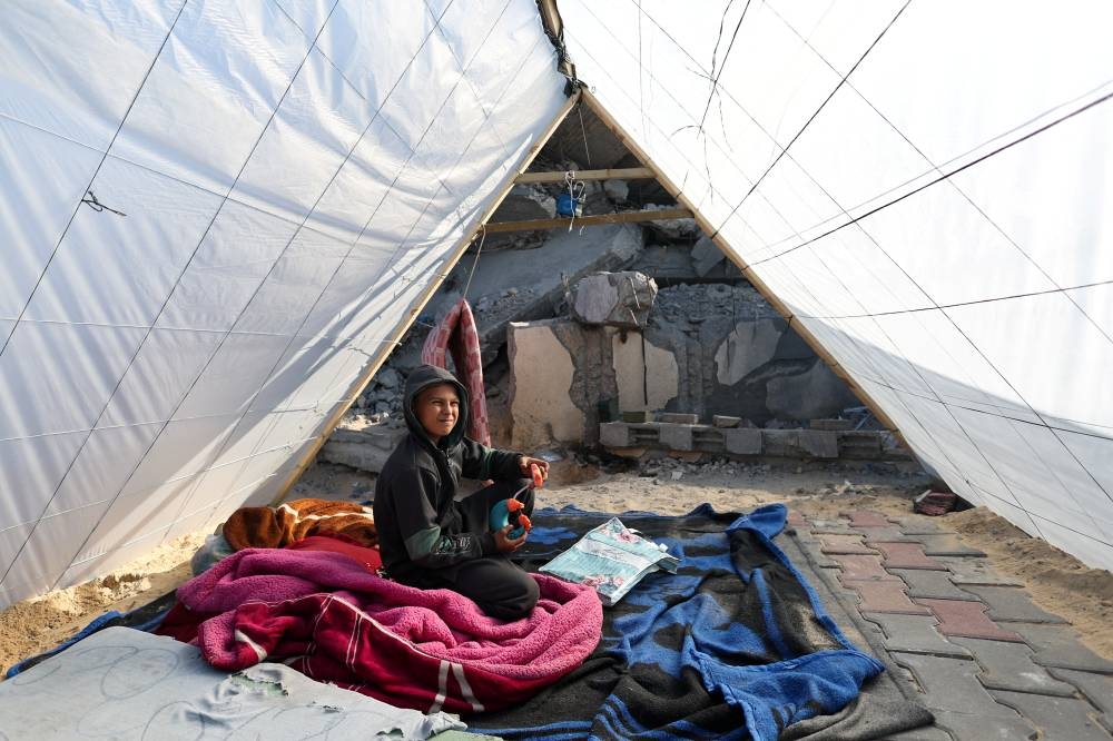 A boys sits as displaced Palestinians, who fled their homes due to Israeli strikes, shelter in a tent camp in Rafah, southern Gaza Strip, on Sunday. REUTERS