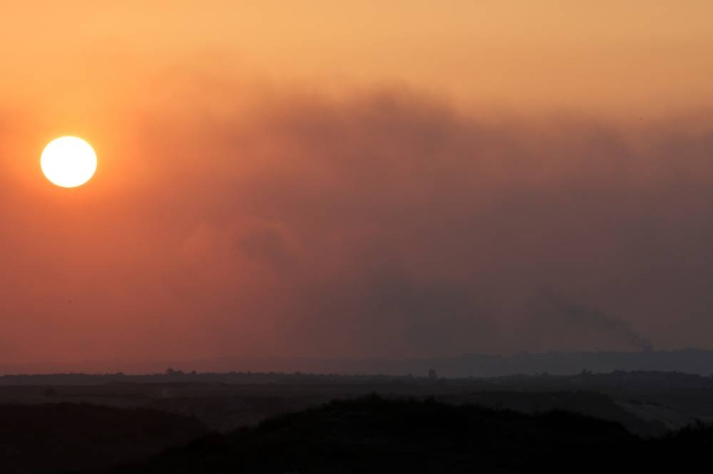 Smoke rises over Gaza at sunset as seen from southern Israel, on Sunday. REUTERS