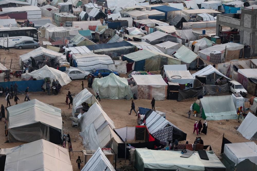 Displaced Palestinians, who fled their homes due to Israeli strikes, shelter in a tent camp on the eve of the new year of 2024, in Rafah, southern Gaza Strip, on Sunday. REUTERS