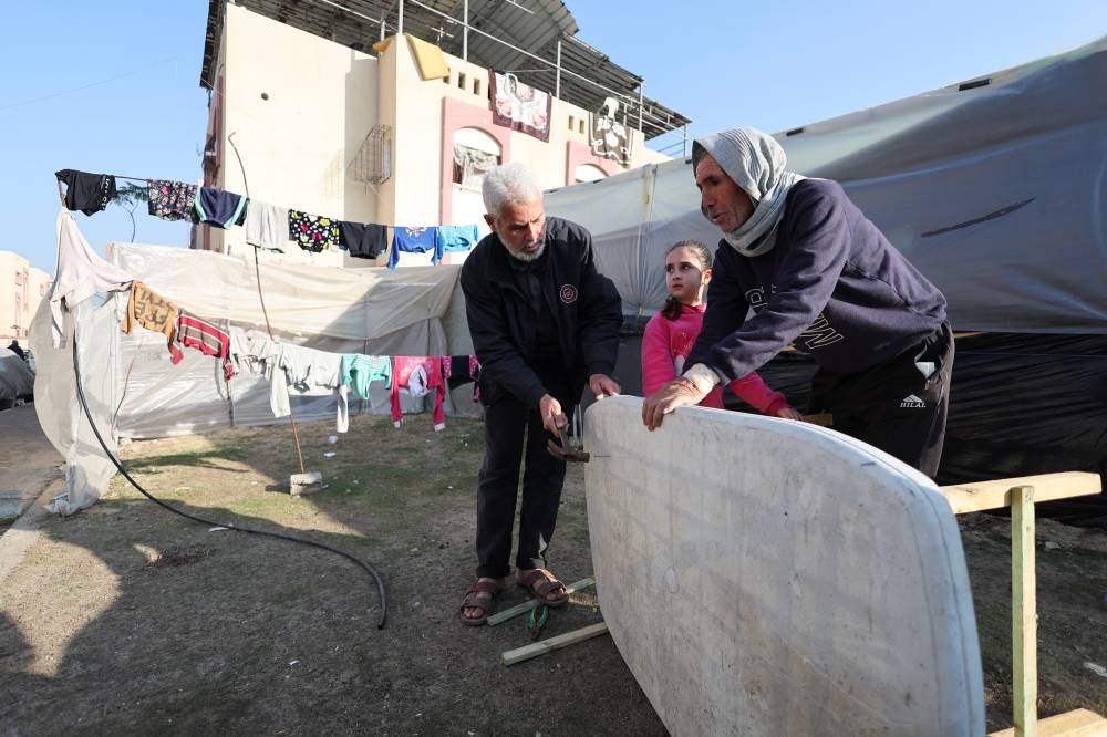 Abu Abdullah Al-Agha, a displaced Palestinian from Khan Younis, builds a makeshift table outside his tent in Rafah, southern Gaza Strip, on Sunday. REUTERS