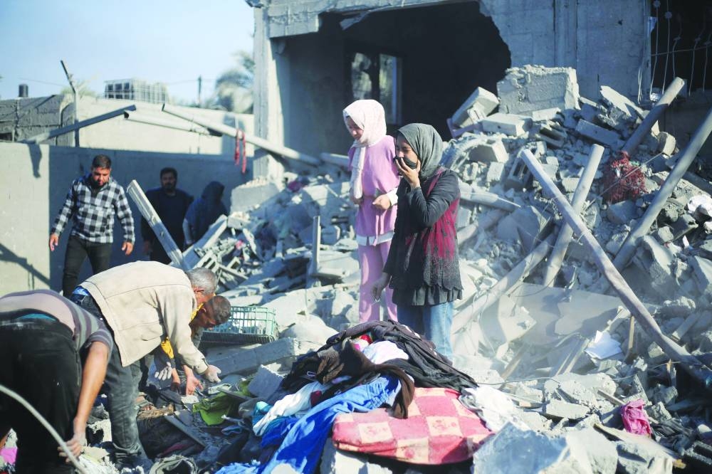 
Palestinians react as they stand on the rubble of their home after an Israeli strike in Khan Yunis, yesterday, amid the ongoing conflict. 