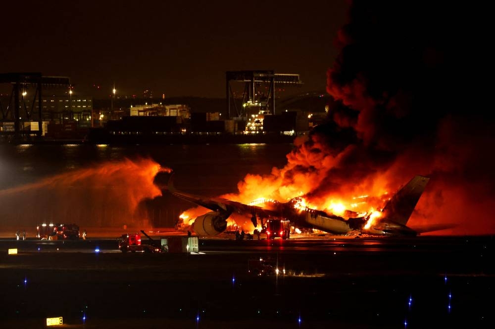 Firefighters work at Haneda International Airport after Japan Airlines' A350 airplane caught on fire,  in Tokyo, Japan on Tuesday. REUTERS