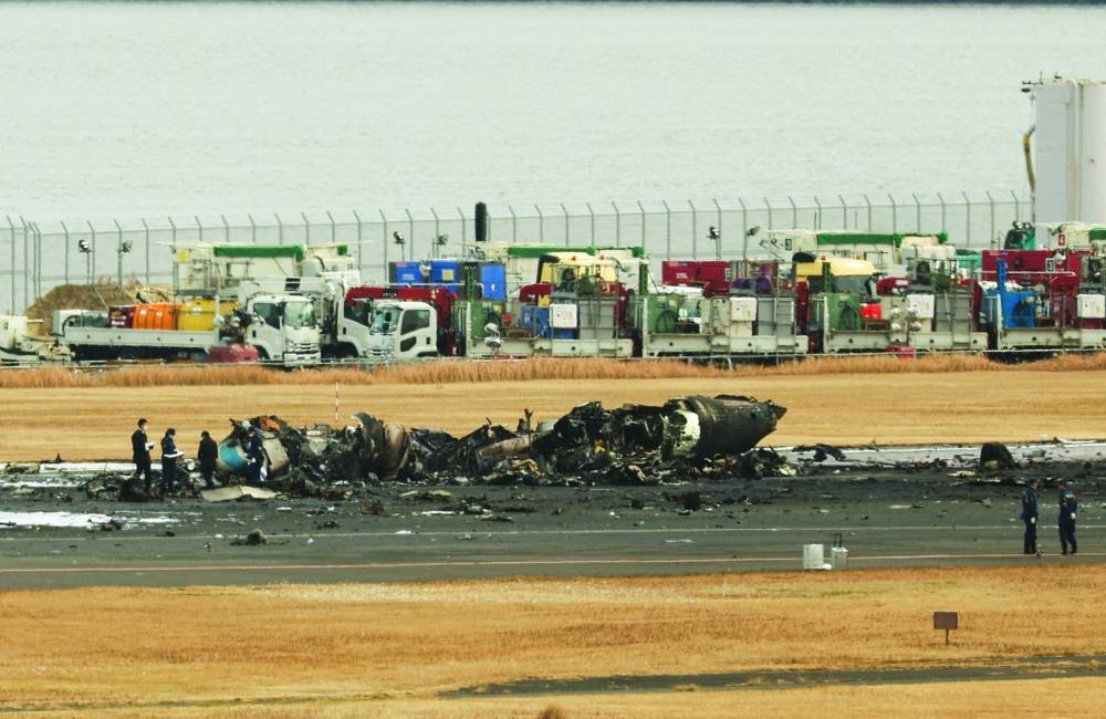 
Officials investigate a burnt Japan Coast Guard aircraft after a collision with Japan Airlines’ (JAL) Airbus A350 plane at Haneda International Airport in Tokyo. 