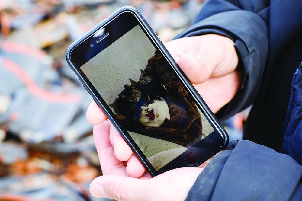 
Japanese lacquer artist Kohei Kirimoto shows a picture of his missing cats, as he searches for them, near to an “Asaichi” morning market which burnt down in a quake-triggered fire, in Wajima. 