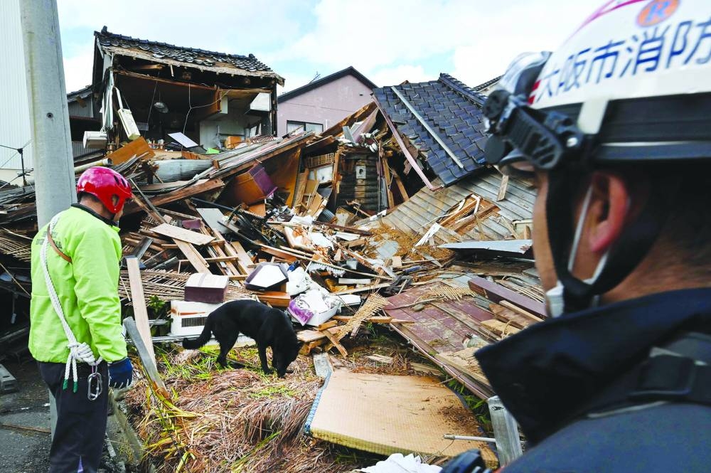 
A rescue dog helps firefighters in searching for people in the rubble of a collapsed house in Wajima, Ishikawa. 