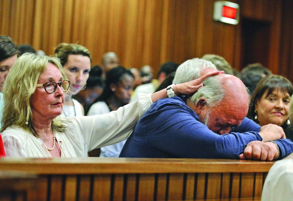 Barry Steenkamp, father of Reeva Steenkamp, is consoled by his wife June Steenkamp during the sentencing hearing of Oscar Pistorius at the North Gauteng High Court in Pretoria, on October 15, 2014.