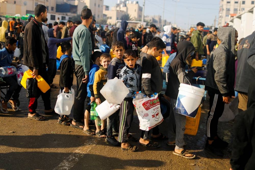 Palestinian children queue as they wait to collect drinking water in Rafah, in the southern Gaza Strip, on Friday. REUTERS