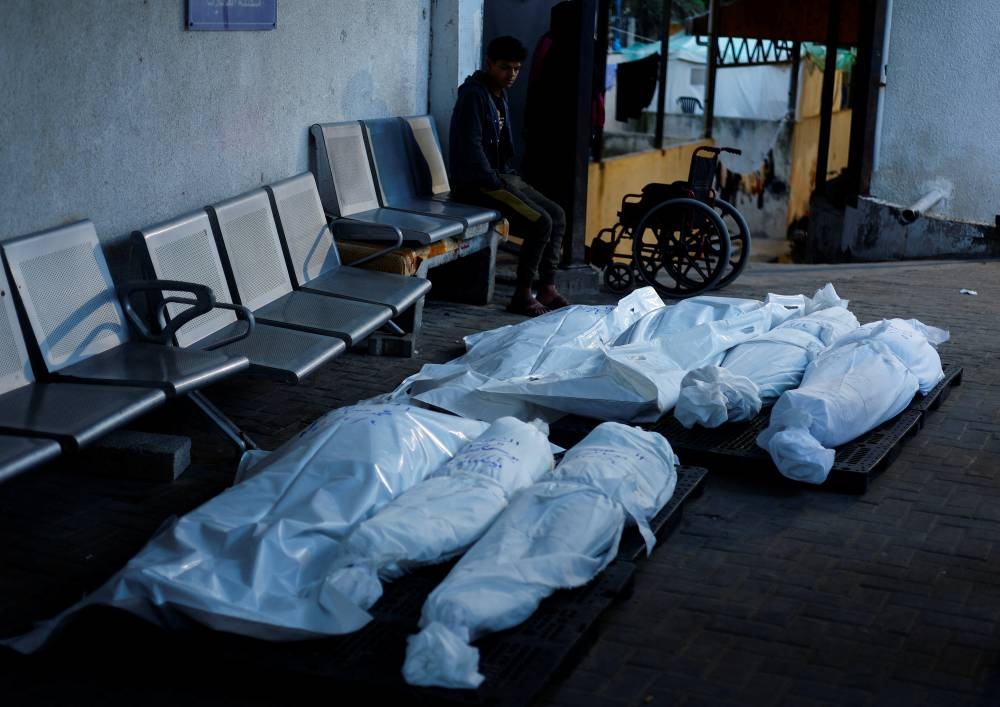 A boy sits near the bodies of Palestinians who were killed in an Israeli strike at Abu Yousef Al Najjar hospital, in Rafah, in the southern Gaza Strip, on Friday. REUTERS