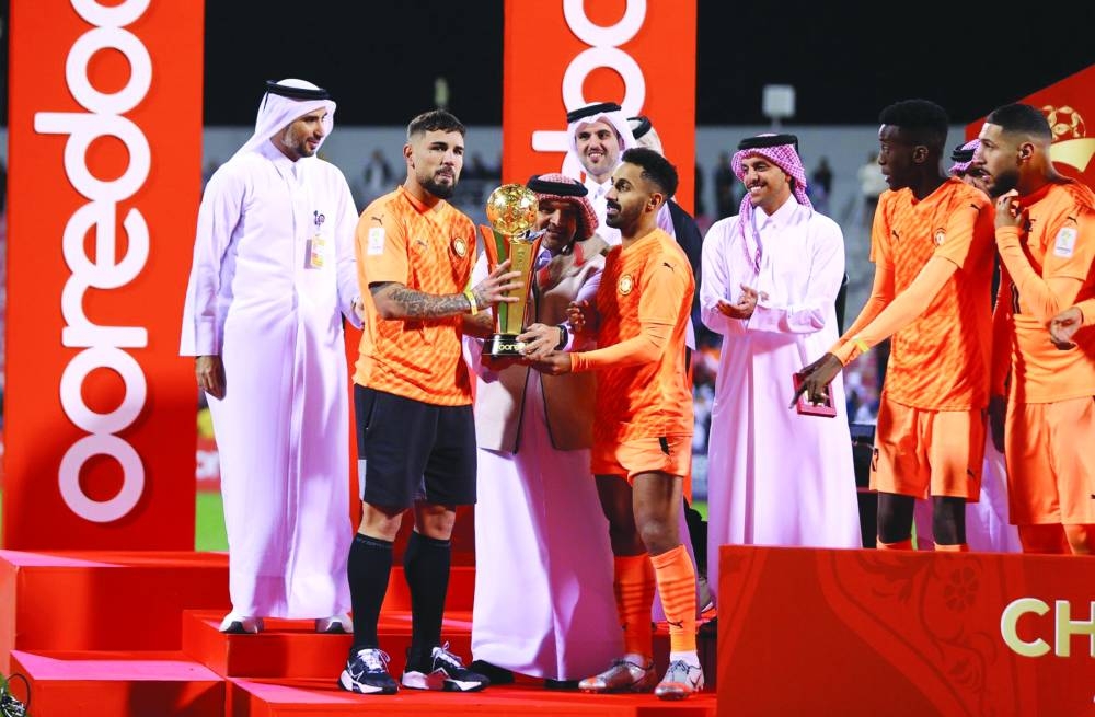Umm Salal players and officials celebrate with the trophy after winning the Ooredoo Cup at the Grand Hamad Stadium on Saturday.