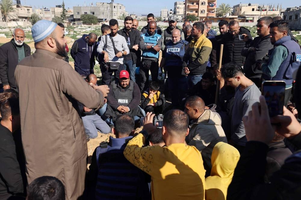 Al Jazeera's bureau chief in Gaza, Wael Al-Dahdouh (C), along with fellow journalists, mourn during the funeral of his son Hamza Wael Dahdouh, a journalist with the Al Jazeera television network, who was killed in a reported Israeli air strike, in Rafah in the Gaza Strip on Sunday. AFP