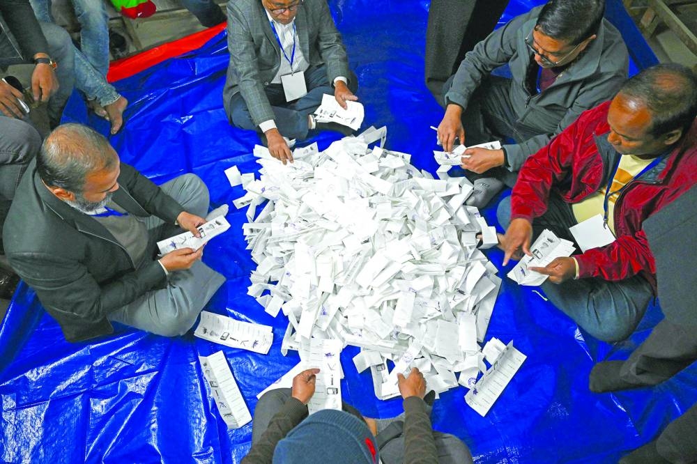 Election officials count ballot papers at a polling booth in Dhaka.