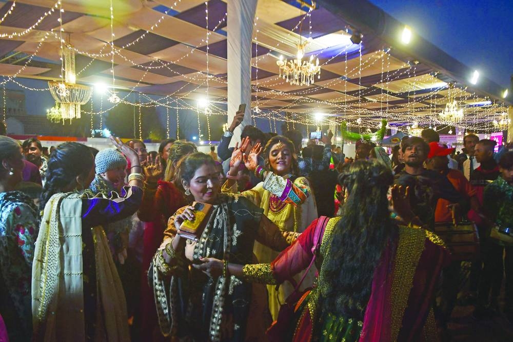 Relatives of the couples dance during the ceremony. (AFP)