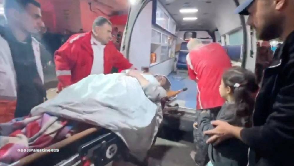 Members of Palestine Red Crescent ambulance teams transfer an injured Palestinian woman on a stretcher from an ambulance to Shuhada al-Aqsa hospital in Deir Al-Balah, in the central Gaza Strip, on Monday. Palestine Red Crescent Society via REUTERS 