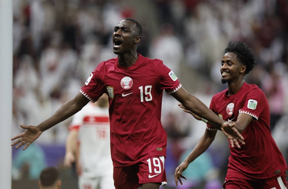 Qatar's Almoez Ali celebrates scoring their second goal with Yusuf Abdurisag. REUTERS
