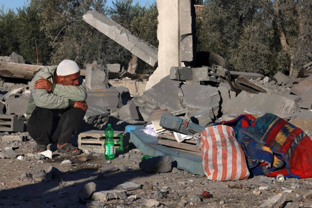 A man sits amid the rubble following Israeli bombardment in Rafah in the southern Gaza Strip on Saturday. AFP 