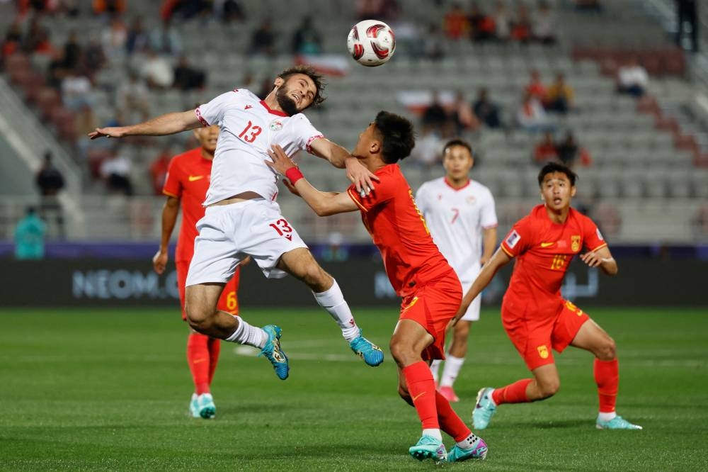Tajikistan's midfielder Amadoni Kamolov vies for a header. AFP