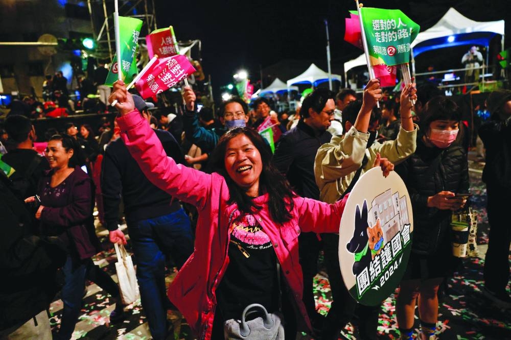 
A supporter of the Democratic Progressive Party dances during a rally, following the victory of Lai Ching-te in the presidential elections, in Taipei. 