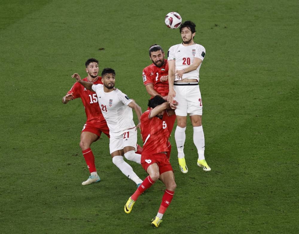 Palestine's Michael Termanini in action with Iran's Sardar Azmoun. REUTERS