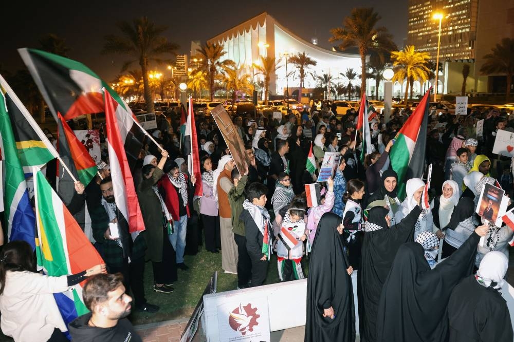 Kuwaitis wave Palestinian and South African flags during during a rally in solidarity with the people of Gaza at Iradah Square in Kuwait City on Sunday. AFP