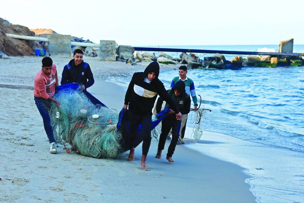Palestinian fishermen work on the beach, amid the ongoing conflict between Israel and Hamas group, in Rafah, in the southern Gaza Strip, yesterday.