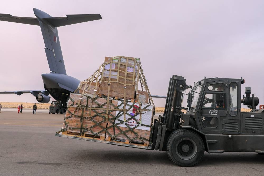 Airport workers unload crates with aid delivered from Qatar, destined for Gaza, at El Arish International Airport, Arish, Egypt on Wednesday. Qatar's Ministry of Foreign Affairs/Handout via REUTERS  