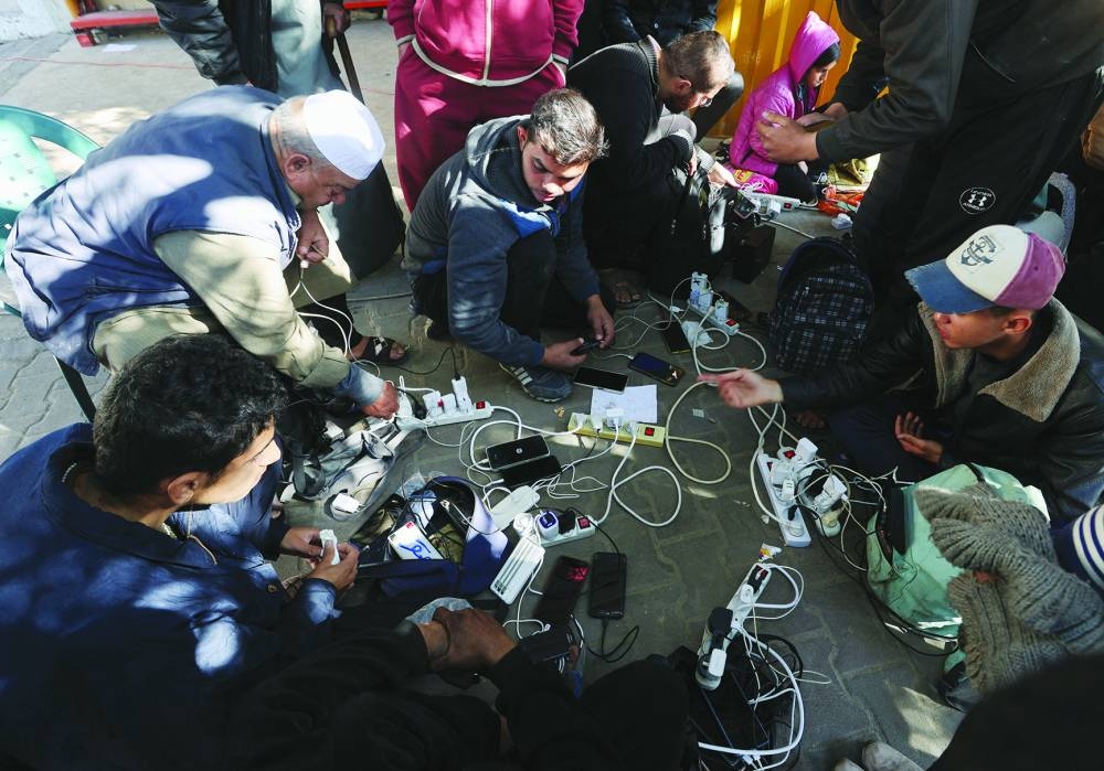 
Palestinians charge their devices outside the Emirati hospital, amid the ongoing conflict between Israel and the Hamas group, in Rafah in the southern Gaza Strip. 