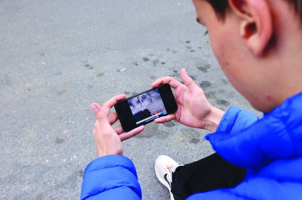 A man in Tehran watches the news on his phone about Pakistan’s air strike.