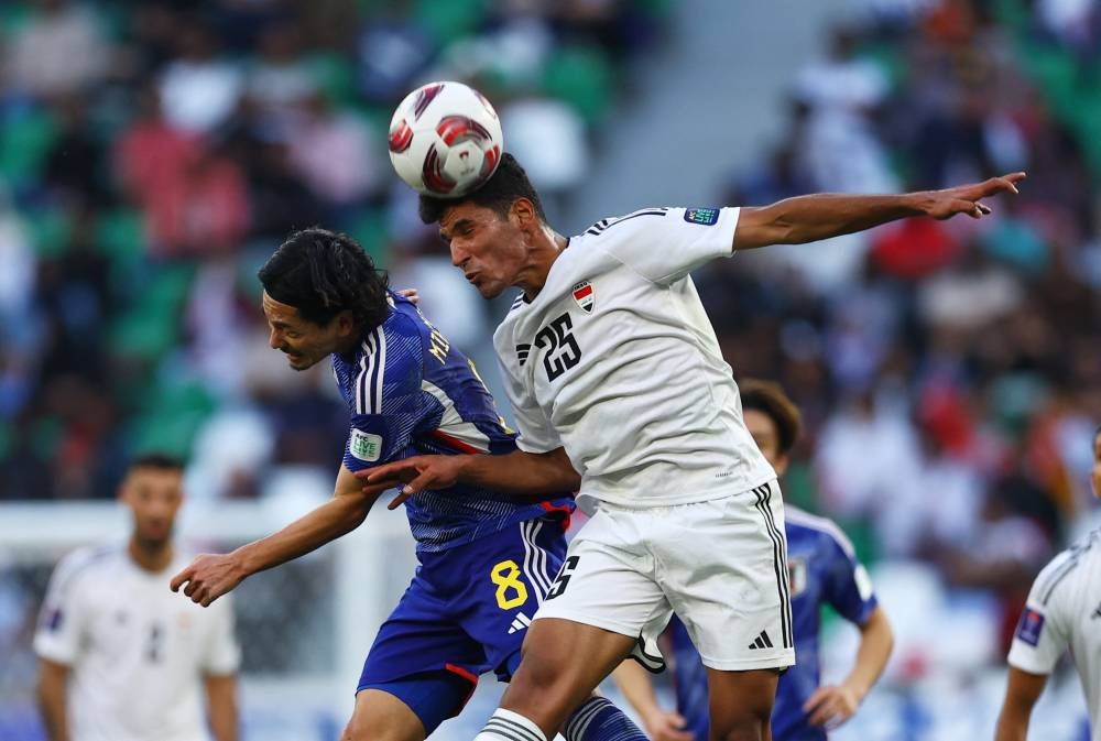 Iraq's Ahmed Al-Hajjaj in action with Japan's Takumi Minamino. REUTERS