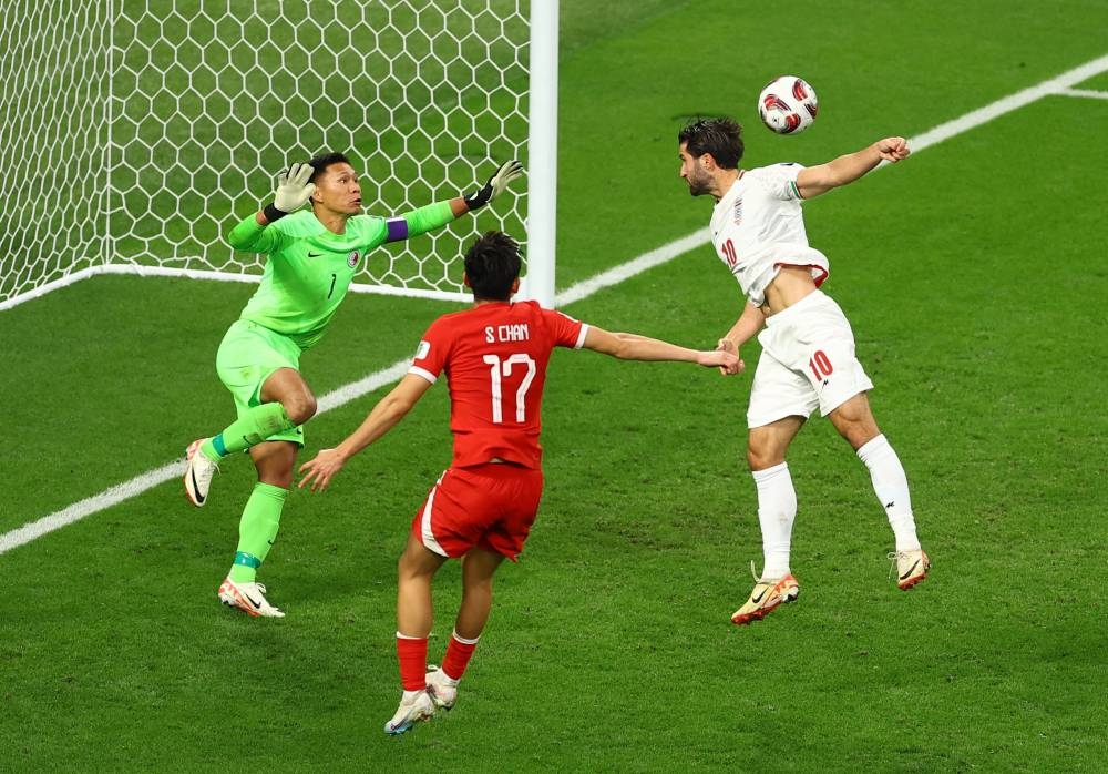 Hong Kong's Yapp Hung Fai and Wong Wai in action with Iran's Karim Ansarifard. REUTERS