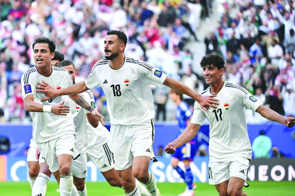 Iraq's forward (No.18) Aymen Hussein celebrates with teammates after scoring his team's second goal during the Qatar 2023 AFC Asian Cup Group D match against Japan at the Education City Stadium in Doha Friday. AFP