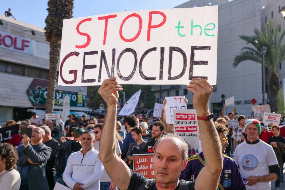People hold placards and shout slogans as they take part in a protest calling for a ceasefire and for the release of Israeli hostages held in Gaza, in the northern port city of Haifa Saturday. AFP