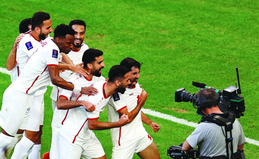 Jordan’s Yazan al-Naimat celebrates with teammates after scoring a goal during their AFC Asian Cup Group E clash against South Korea at Al Thumama Stadium in Doha on Saturday. (Reuters)